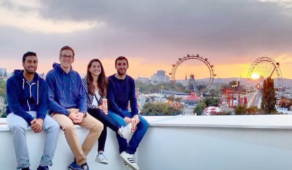 Four students sitting on a ledge in Vienna